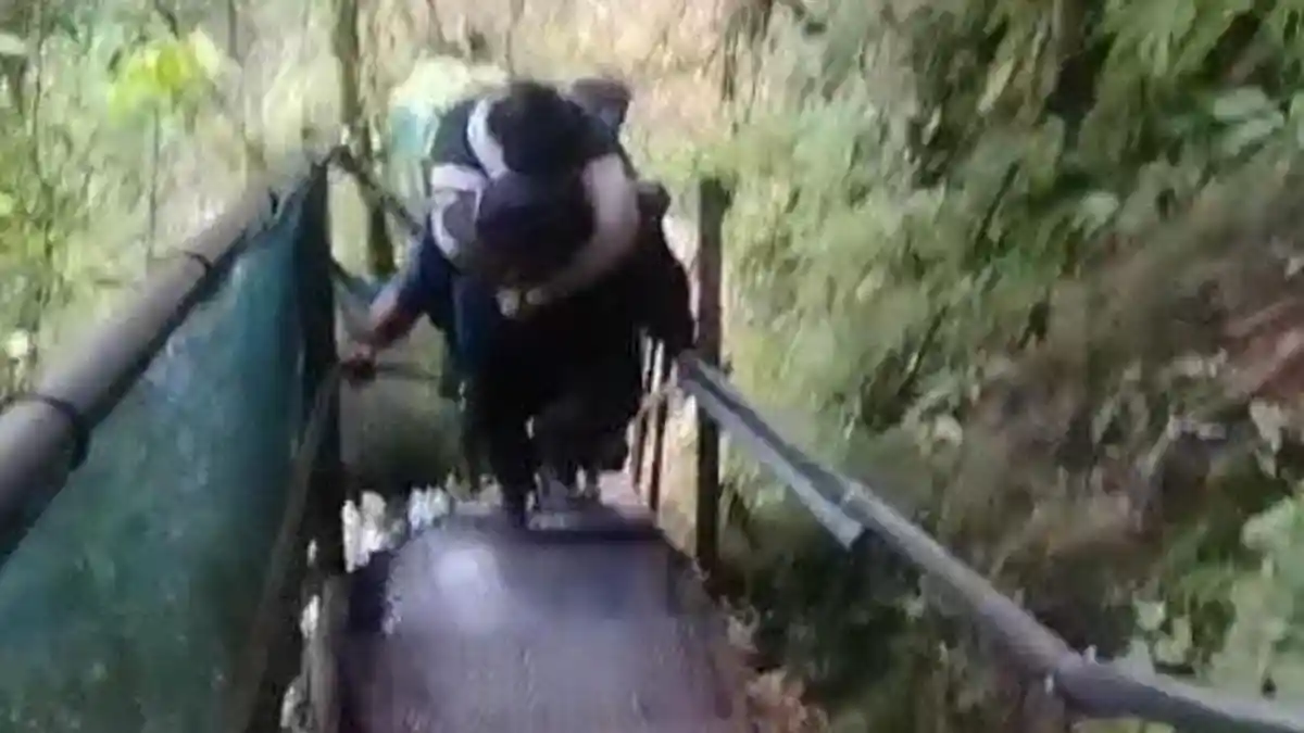 Petugas pengelola Air Terjun Tumpak Sewu Lumajang memberikan layanan gendong gratis bagi wisatawan