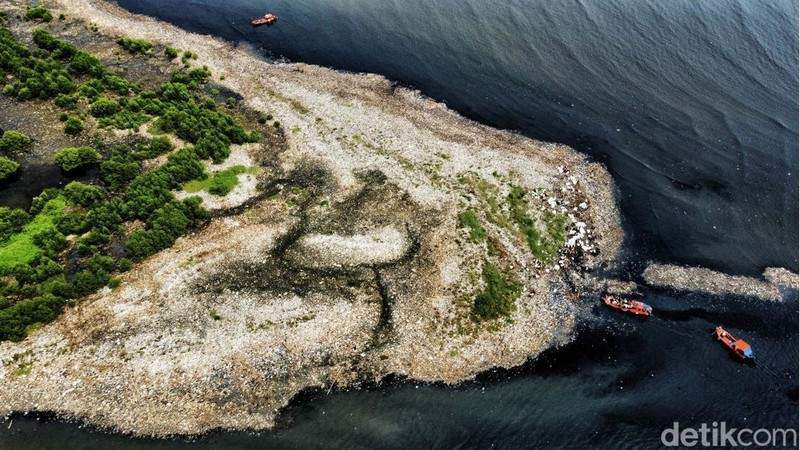 Petugas gabungan membersihkan pulau sampah di pesisir Jakarta Utara