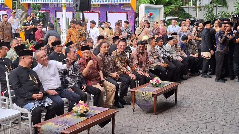 Anies Baswedan dan Ahok duduk berdampingan serta tertawa bersama di Balai Kota Jakarta