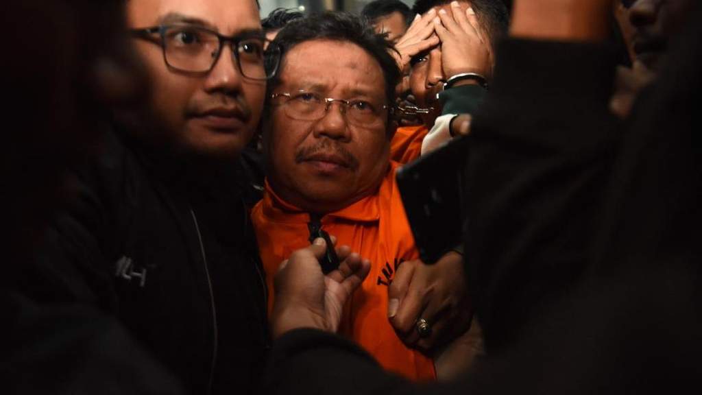 Gedung KPK dengan ilustrasi borgol dan logo partai politik terkait OTT kepala daerah
