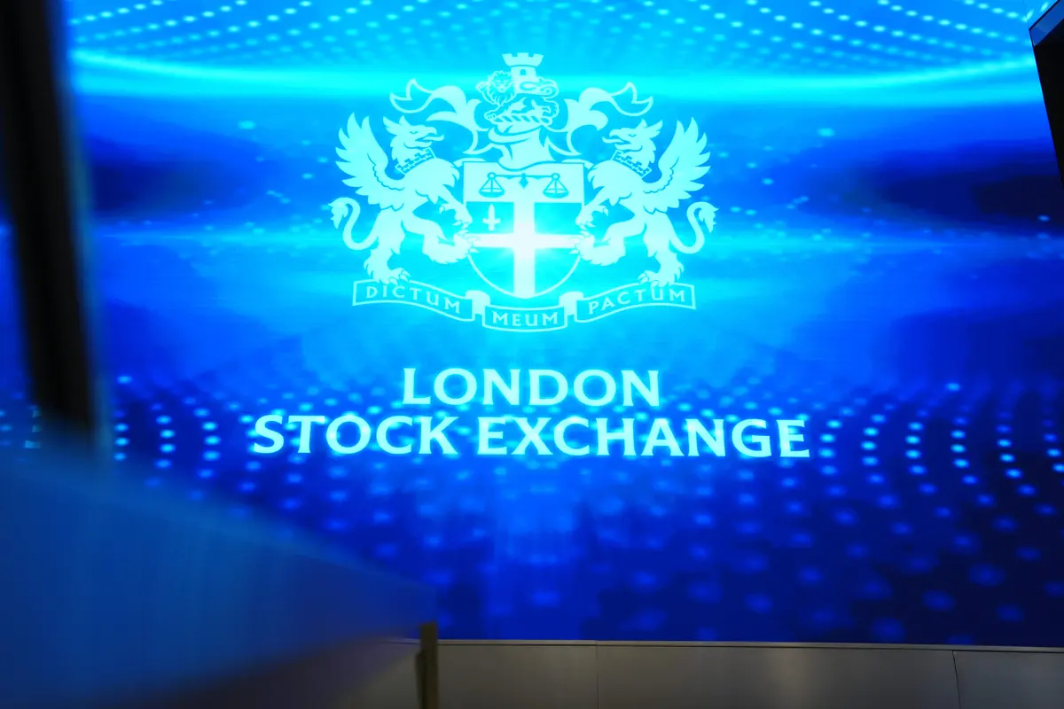 Suasana perdagangan di bursa saham London FTSE 100 dengan grafik harga minyak