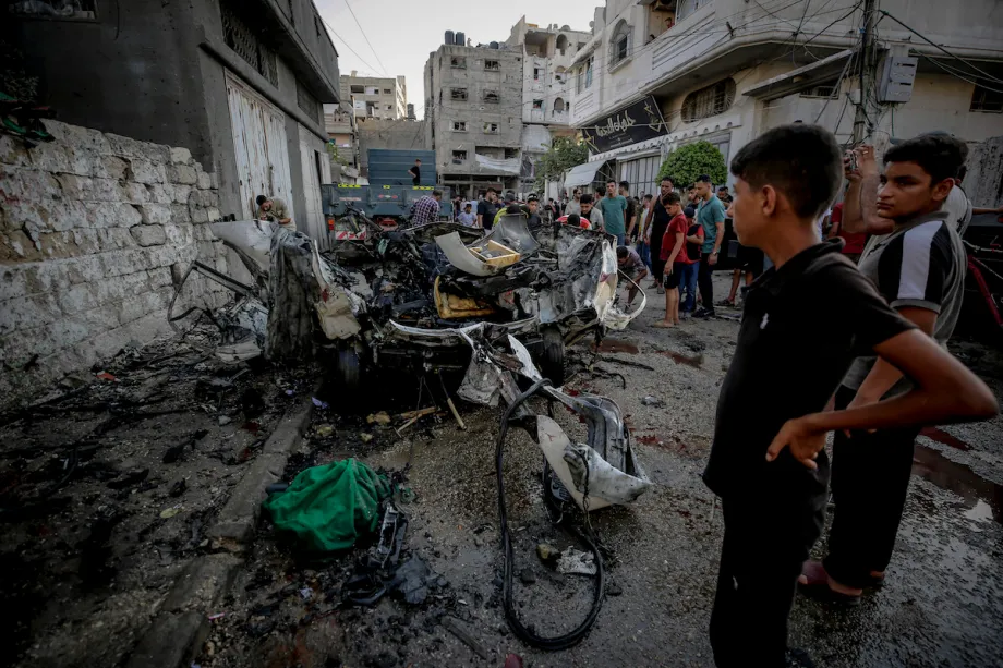Warga Palestina memeriksa kendaraan hancur setelah serangan Israel di Kota Gaza.