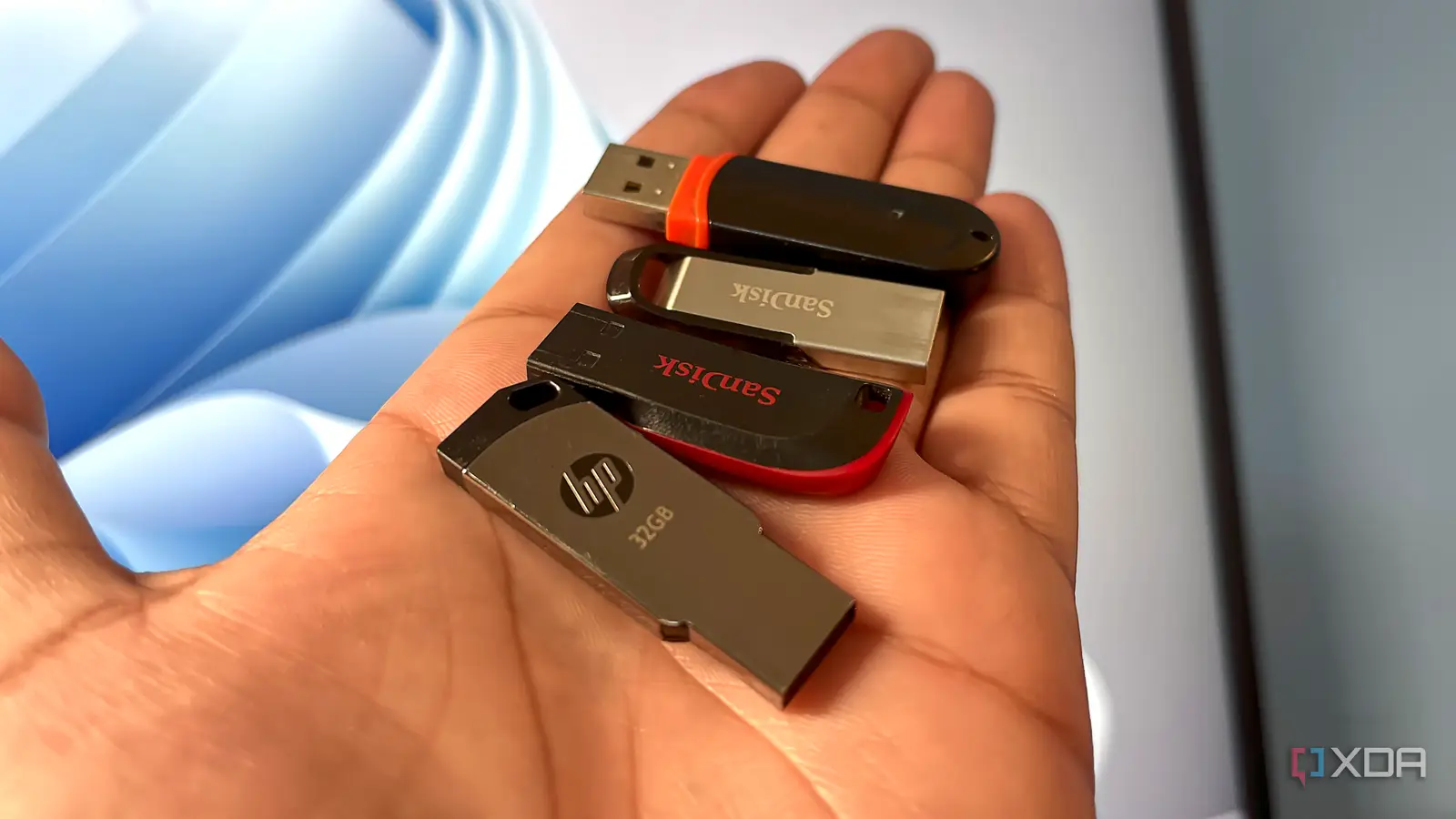 Flash drive USB kecil yang diletakkan di atas meja kerja dekat komputer