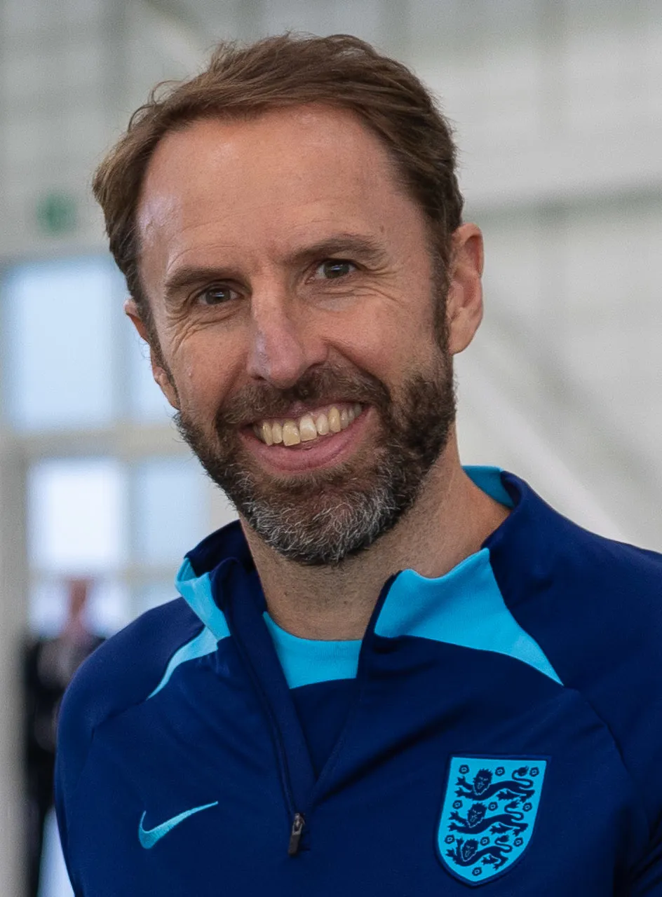 Foto Gareth Southgate mengenakan jas formal dengan ekspresi tenang di pinggir lapangan