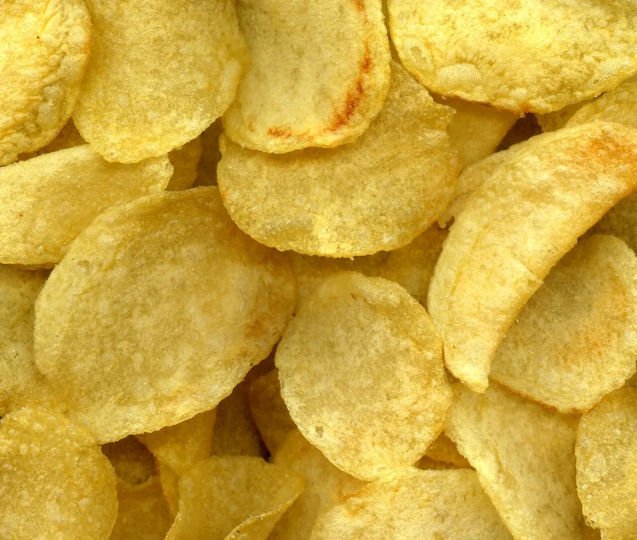 Tumpukan keripik kentang renyah dengan bumbu dan rempah pilihan sebagai camilan populer dunia