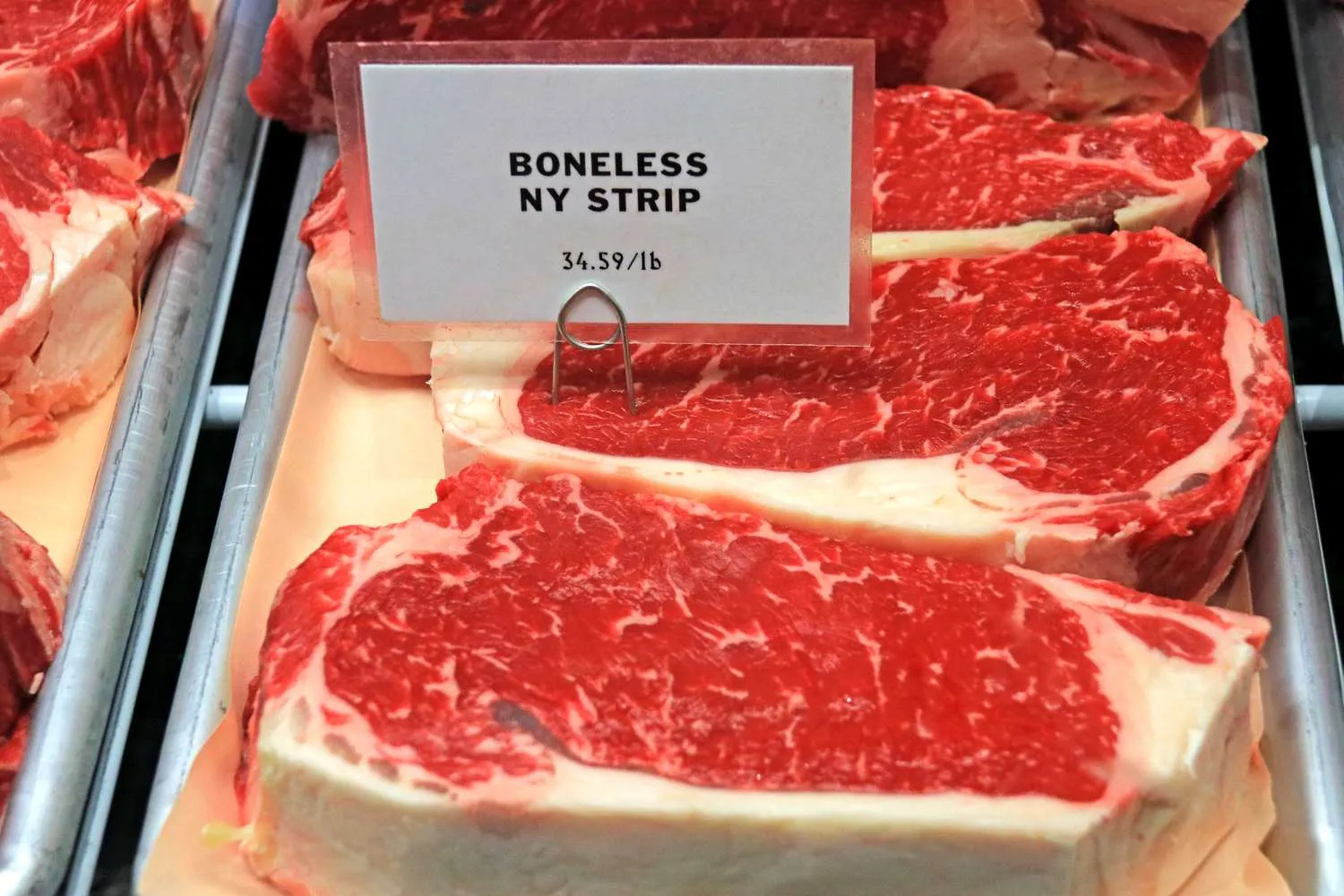 Potongan skirt steak segar dengan marbling sempurna di atas talenan kayu