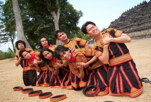 Sekelompok penari pria melakukan Tari Saman dengan gerakan kompak dan rapi