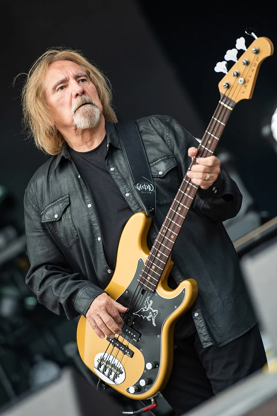 Geezer Butler tampil di atas panggung bersama band heavy metal Black Sabbath
