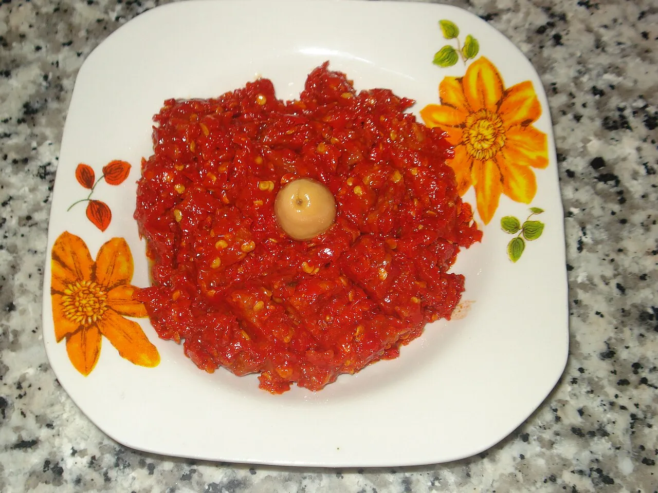 Mangkok berisi pasta cabai Harissa tradisional lengkap dengan cabai merah dan rempah-rempah