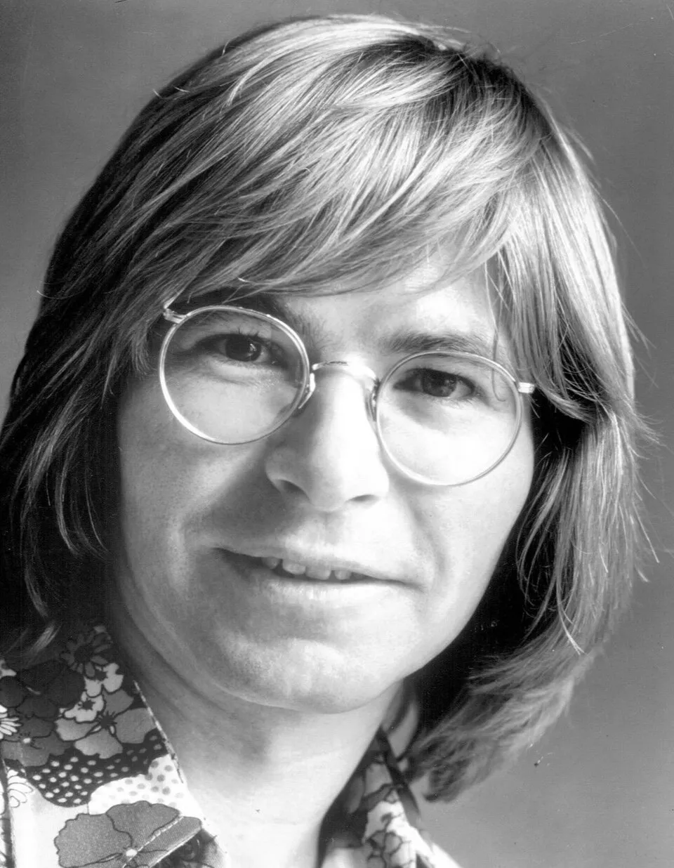 Musisi legendaris John Denver dengan gitar akustik dan kacamata khasnya
