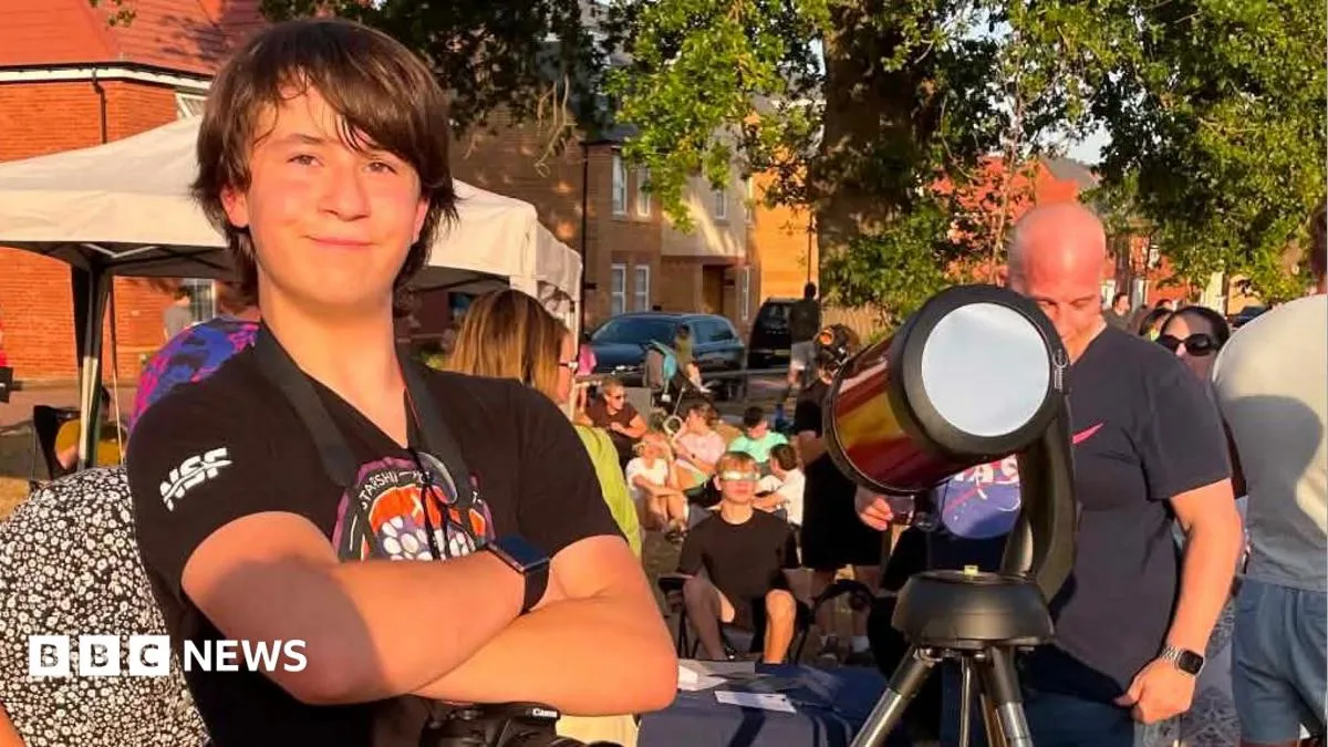Remaja astronom Aston Smith menyiapkan teleskop dalam acara pesta gerhana matahari di Overstone