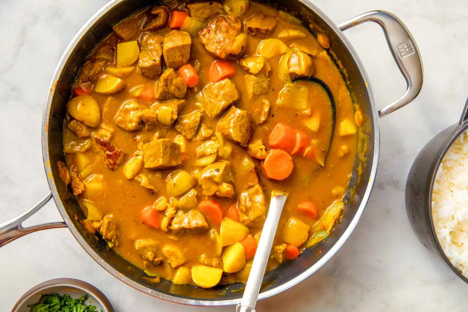 Mangkok berisi japanese beef curry hangat dengan nasi putih dan taburan peterseli