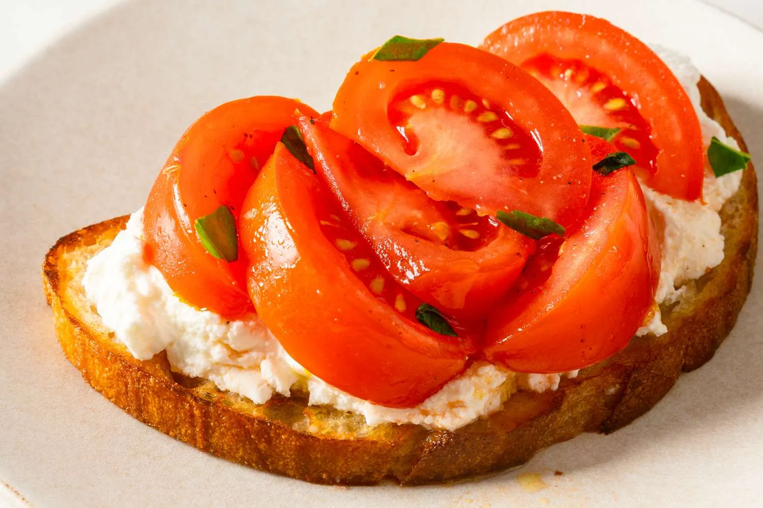 Hidangan marinated tomato salad segar dengan taburan daun basil
