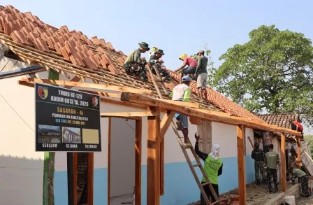 Satgas TMMD 129 Bojonegoro dan warga pasang genteng rumah Bu Tini