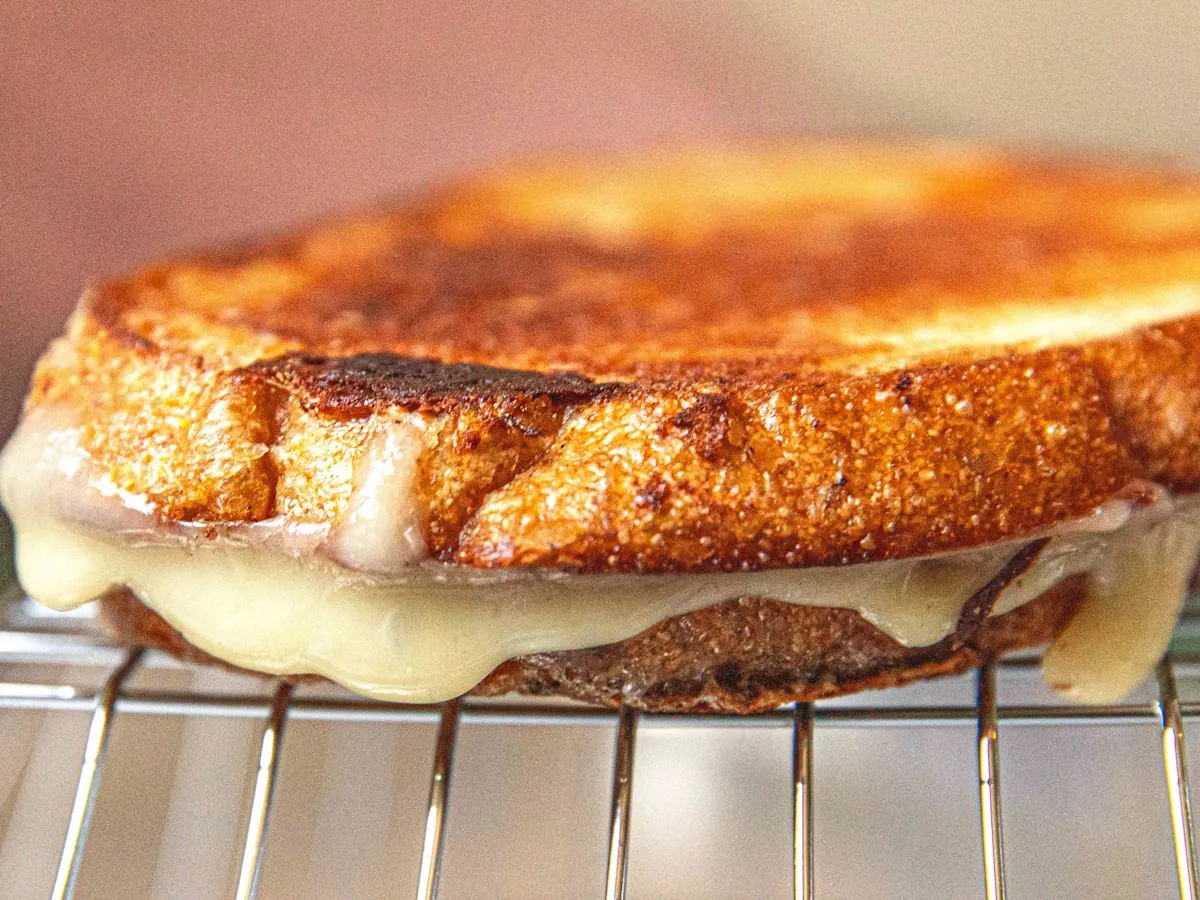 Roti panggang keju hangat di atas rak kawat agar tetap renyah