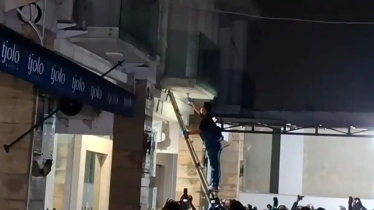 Penyidik kepolisian menggunakan tangga mencopot perangkat diduga CCTV saat menggeledah ruko Cipete.