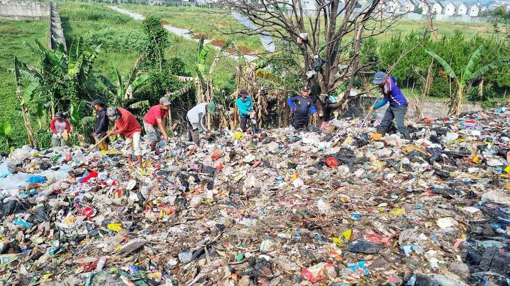 Petugas DLH Kabupaten Bandung membersihkan tumpukan 300 ton sampah liar di Ciganitri Bojongsoang